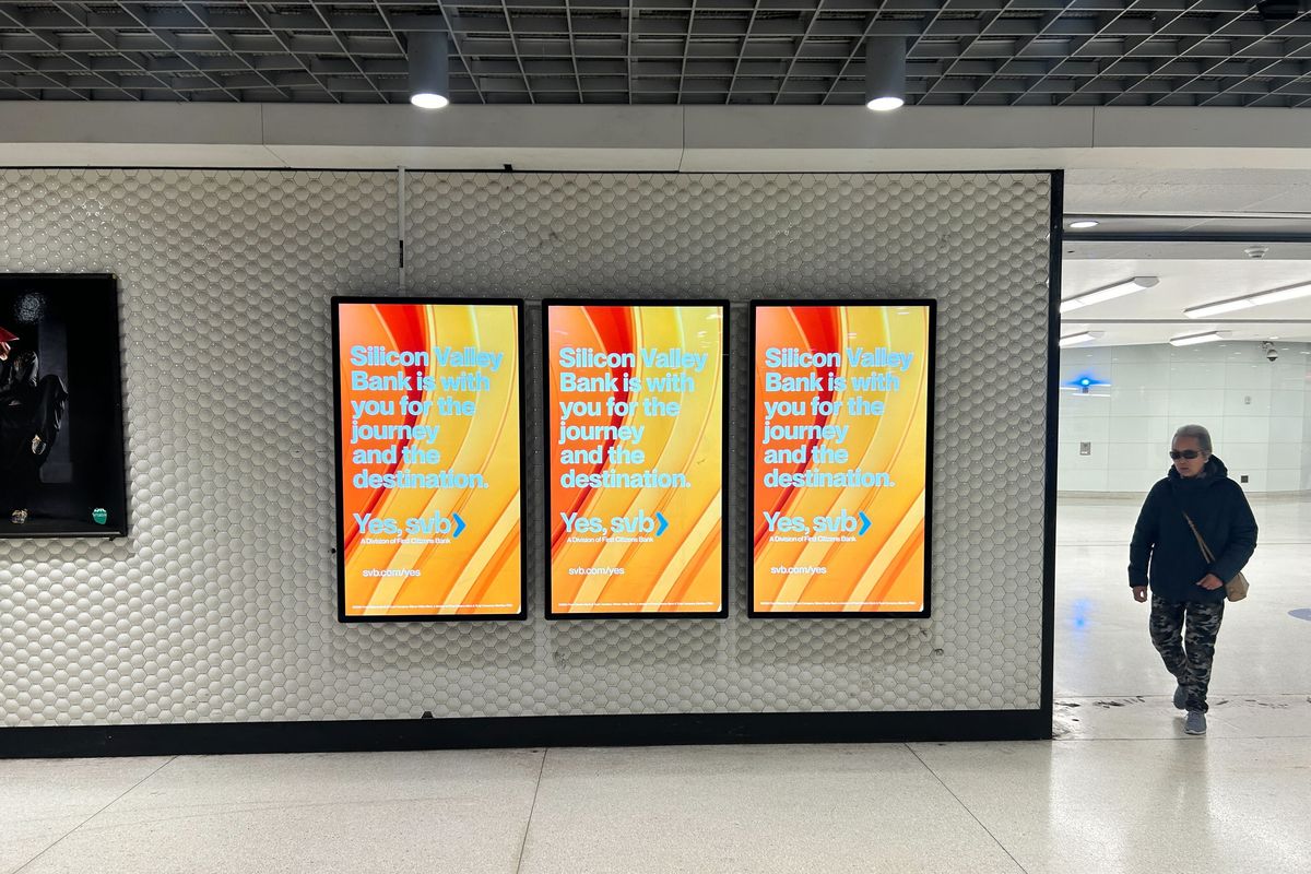 A person walks by ads for Silicon Valley Bank in a Bay Area Rapid Transit station in San Francisco on Thursday.  (Heather Kelly/The Washington Post)