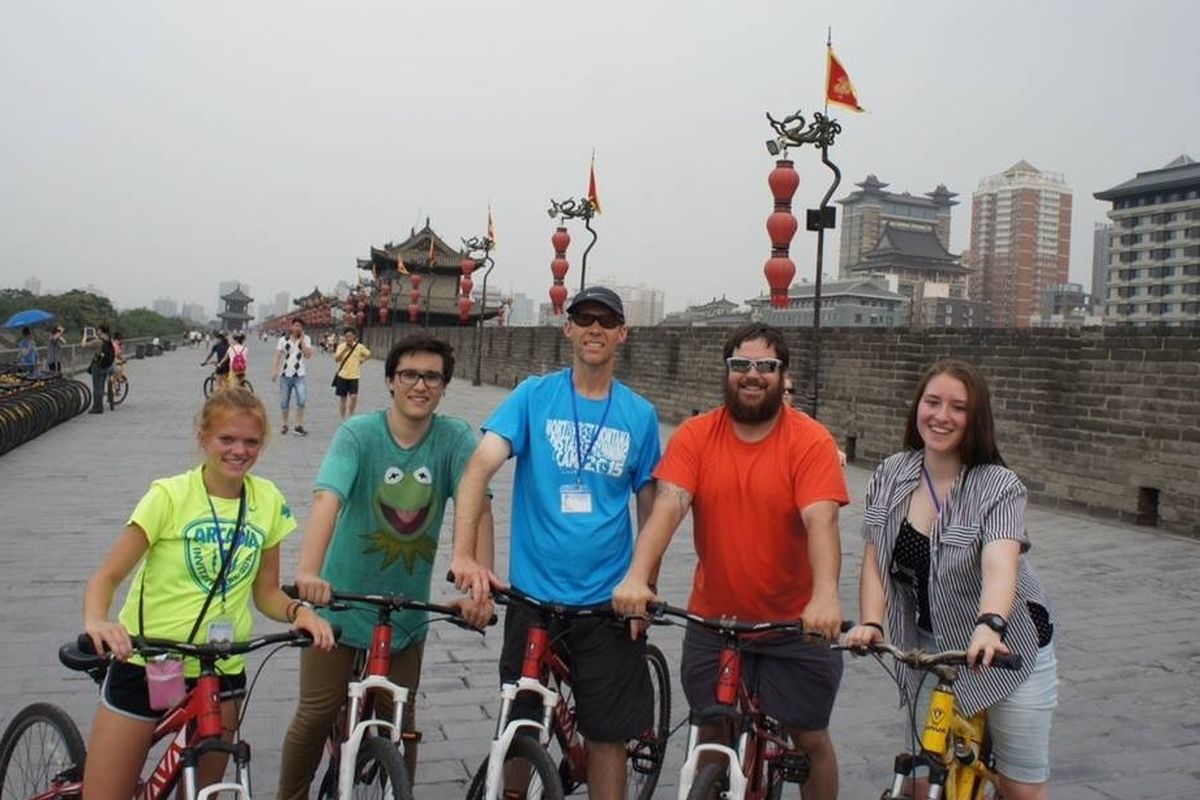 From left, McCall Skay, Dakota Wurle, Ty Brown, Justin Farwell and Rachel Wilson pose with their bicycles at the wall surrounding the city of Xi’an, China.