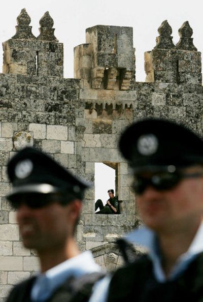 
An Israeli border police officer sits in the overlook at Damascus Gate as other police officers stand guard following traditional Friday prayers in Jerusalem's Old City on Friday. 
 (Associated Press / The Spokesman-Review)