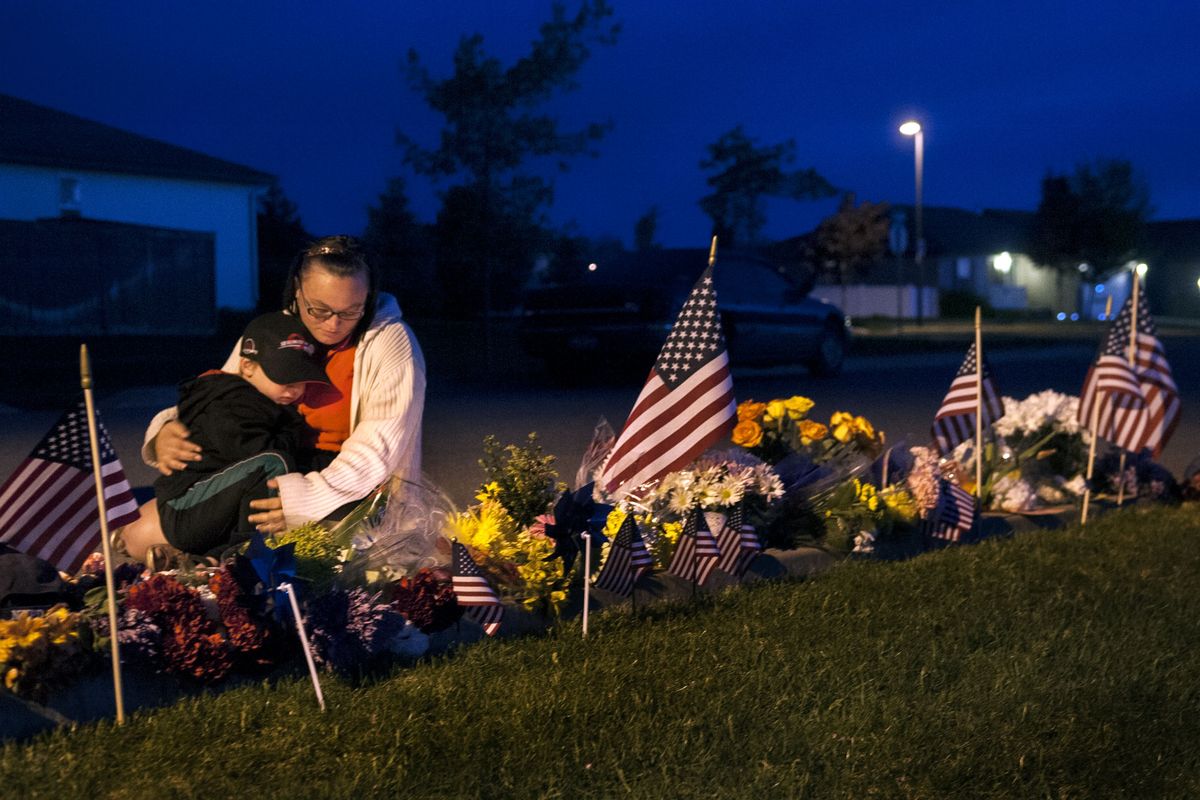 “He was my friend,” Sunshine Smith said to her son Stuart Cornelsen, 4, as they visited the site on Wednesday where Coeur d’Alene police Sgt. Greg Moore was shot Tuesday morning. Smith was a student at Lakes Middle School when Moore was a resource officer there. (Kathy Plonka)