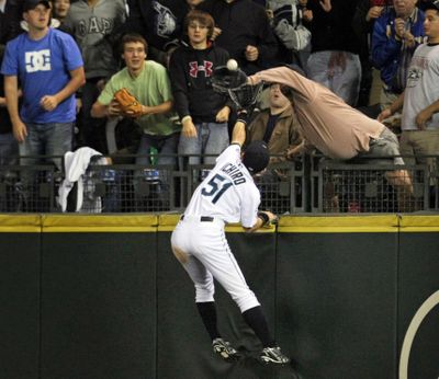 ORG XMIT: WASET101 A fan reaches out to take a catch away from Seattle Mariners' Ichiro Suzuki on home run hit by New York Yankees' Hideki Matsui in the eighth inning of a baseball game on Thursday, Aug. 13, 2009, in Seattle. (AP Photo/The Seattle Times, Jim Bates) OUTS: SEATTLE OUT, USA TODAY OUT, MAGAZINES OUT, SALES OUT. MANDATORY CREDIT TO:  JIM BATES/THE SEATTLE TIMES. (Jim Bates / The Spokesman-Review)