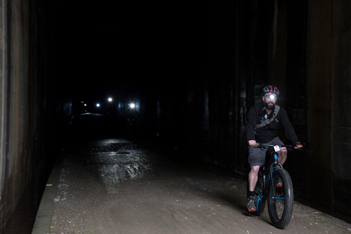 Bikers exit the 1.66 mile long St. Paul tunnel on the Hiawatha trail Saturday June 23, 2018. The 15-mile-long trail is celebrating its 20th anniversary this year. ELI FRANCOVICH/THE SPOKESMAN REVIEW (Eli Francovich / The Spokesman-Review)