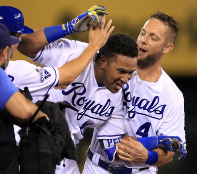 Kansas City Royals Whit Merrifield, left, and Alex Gordon, top right, congratulate teammate Salvador Perez, middle, after his winning two-run double during the ninth inning Thursday against visiting Seattle. (Orlin Wagner / Associated Press)