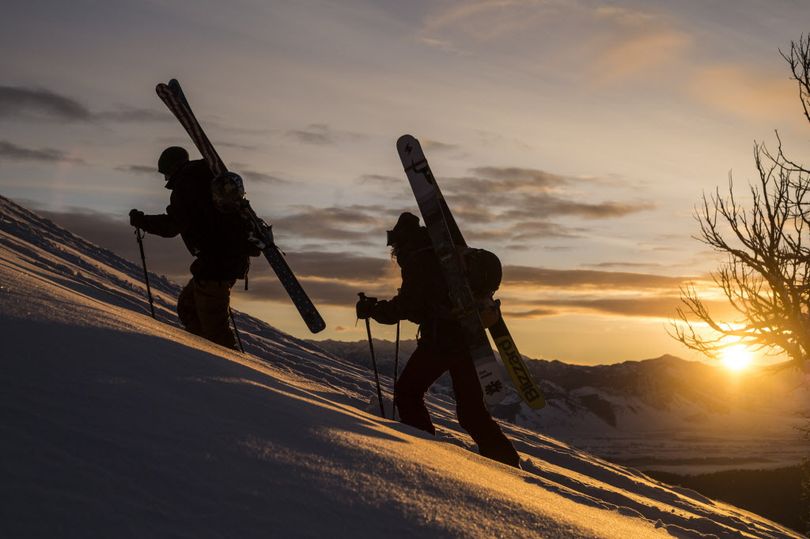 Skiers climb to reach a high point for a run. (Associated Press)