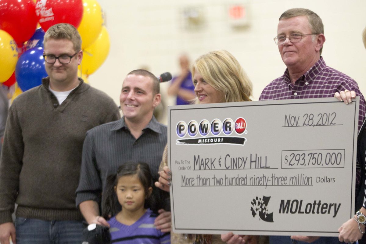 Mark and Cindy Hill hold a Powerball check with their three of their four children,  Jarod, left, Cody and six-year-old Jaiden in Dearborn, Mo., Friday, Nov. 30, 2012. (Orlin Wagner / Associated Press)