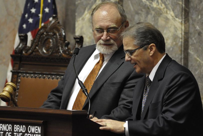 OLYMPIA -- A pair of legislative veterans, Sen. Jim Hargrove, D-Hoquiam, and Lt. Gov. Brad Owen, share a moment at the rostrum Thursday evening. Both are retiring at the end of the year. (Jim Camden/The Spokesman-Review)