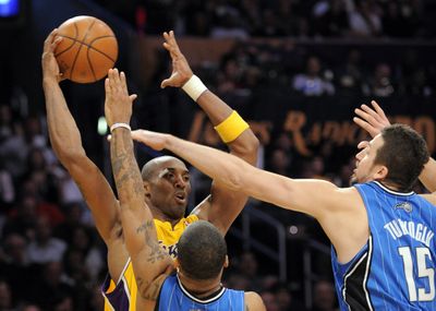 Magic’s Hedo Turkoglu, right, and Jameer Nelson harass Kobe Bryant. (Associated Press / The Spokesman-Review)