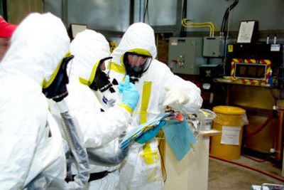 
 Workers at the Accelerated Retrieval Project at the U.S. Department of Energy's Idaho National Laboratory near Idaho Falls prepare to enter a controlled area where radioactive waste is being removed from burial pits, repackaged in casks and shipped to a permanent disposal site out of state.
 (Associated Press / The Spokesman-Review)
