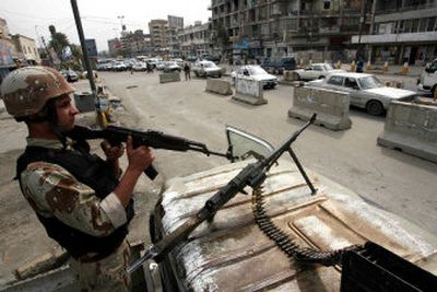
An Iraqi  soldier watches traffic at a  checkpoint in Baghdad on Thursday. 
 (Associated Press / The Spokesman-Review)