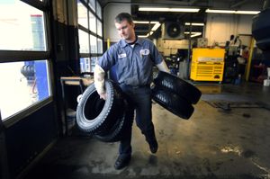 Peter Geissinger, a mechanic with Perfection Tire and Auto Repair at 604 E. Second Ave., prepares to bag up snow tires that were removed from a car Monday. A bill has been introduced in the state legislature that would ban the sale or use of studded tires.   (Colin Mulvany / The Spokesman-Review)