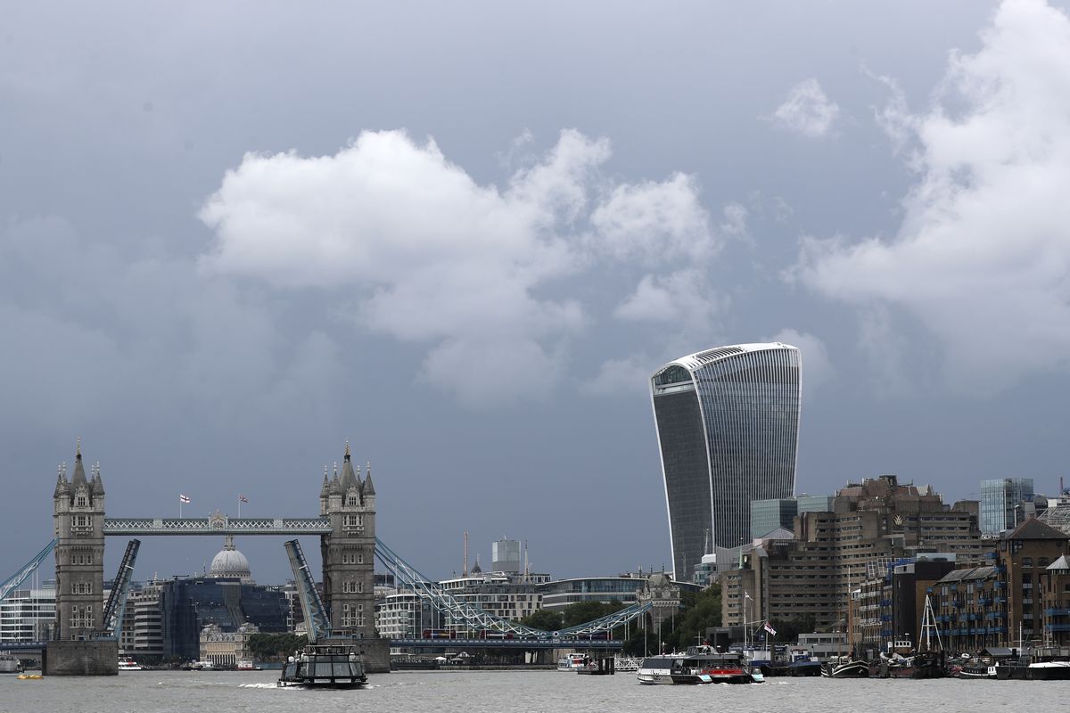 A boat sails down the River Thames in London, Monday Aug. 9, 2021 in front of Tower Bridge that is stuck in the fully open position due to a technical fault.  (Tony Hicks)