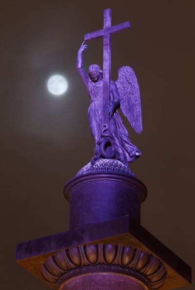 The full moon rises among the clouds behind a statue of an angel fixed atop the Alexander Column at Palace Square in St.Petersburg, Russia, late Monday, Jan. 9, 2012. (Dmitry Lovetsky / Associated Press)