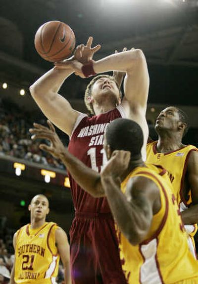 
Washington State's Aron Baynes loses ball while surrounded by Trojans. 
 (Associated Press / The Spokesman-Review)