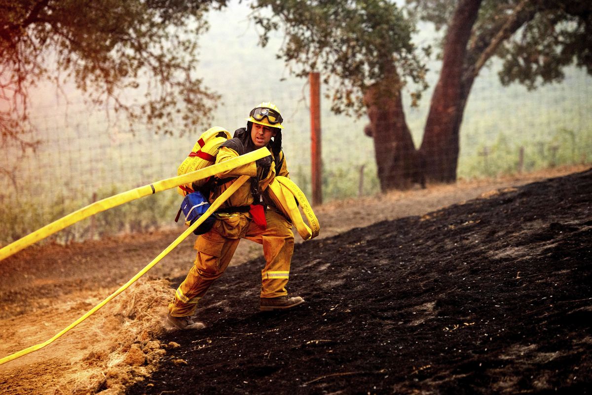 A firefighter battles the Glass Fire burning in a Calistoga, Calif., vineyard Thursday, Oct. 1, 2020. (Noah Berger)
