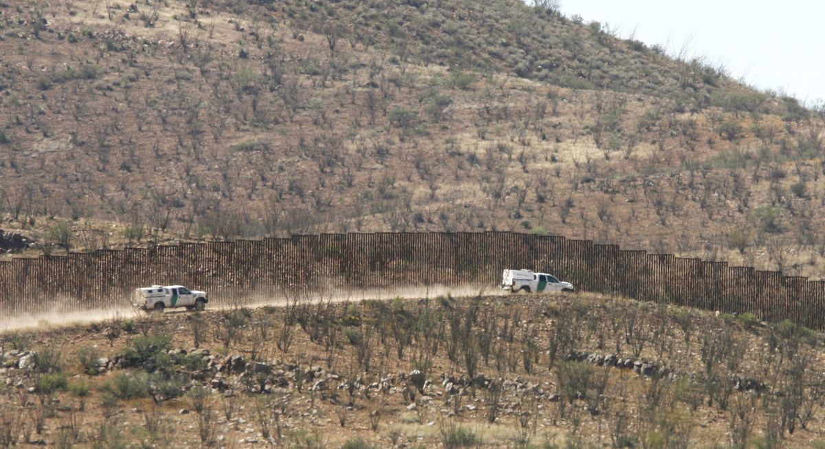U.S. Border Patrol vehicles parallel the U.S.-Mexico border fence in the area where a Border Patrol agent was shot and killed on Tuesday October 2, 2012 west of Douglas, Arizona.  One agent was killed and another wounded in the incident. (Benjie Star / Arizona Daily Star)