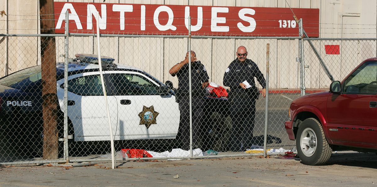 Fresno police officers look over the area where a man killed himself after shooting people in his workplace that killed at least one person and wounded several others at Valley Protein, formally known as Apple Valley Farms Tuesday, Nov. 6, 2012, in Fresno, Calif. Police say a parolee who worked at the  Fresno chicken processing plant opened fire at the business on Tuesday, killing one person and wounding three others, before shooting himself. Police Chief Jerry Dyer said they didn