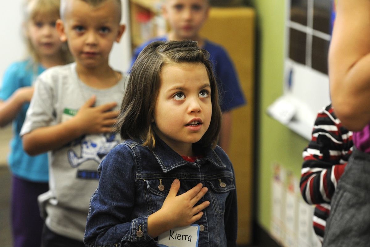 Kindergartner Kierra Moore recites the Pledge of Allegiance at the beginning of her first day of school at Westview Elementary in north Spokane on Tuesday. This year Spokane Public Schools is offering full-day kindergarten at all elementary schools. (Jesse Tinsley)