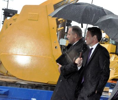 Treasury Secretary Timothy Geithner, right, walks among Caterpillar tractors headed for China from the Port of Tacoma during a rain squall Tuesday, May 18, 2010. (Jim Camden / The Spokesman-Review)