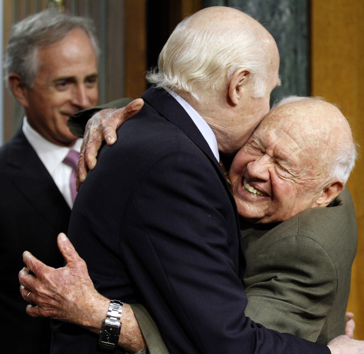 FILE - In this Wednesday, March 2, 2011, file photo, Senate Aging Committee Chairman Sen. Herb Kohl. D-Wis., center, gets a hug from entertainer Mickey Rooney, right, on Capitol Hill in Washington, as Sen. Bob Corker, R-Tenn., looks on at left, prior to Rooney testifying about elder abuse, before the committee. Rooney, a Hollywood legend whose career spanned more than 80 years, has died. He was 93. Los Angeles Police Commander Andrew Smith said that Rooney was with his family when he died Sunday, April 6, 2014, at his North Hollywood home. (Alex Brandon / Associated Press)
