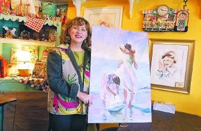 
Annette Carter poses in her Liberty Lake business, The Art Chalet, with one of her oil paintings, 