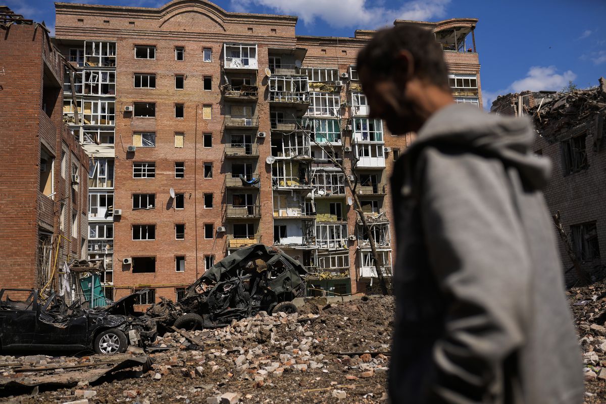 FILE - A man walks next to heavily damaged buildings and destroyed cars following Russian attacks in Bakhmut, Donetsk region, eastern Ukraine, Tuesday, May 24, 2022. The region, along with neighboring Luhansk, is part of the Donbas, where Russian forces have focused their offensive.  (Francisco Seco)