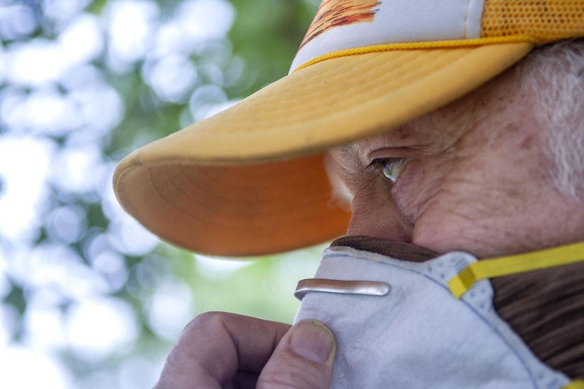 Steel Orr wears a mask while cutting grass in Spokane on Monday, Aug. 20, 2018. Spokane’s air quality early Monday was the worst in the nation, according to the Environmental Protection Agency. (Kathy Plonka / The Spokesman-Review)