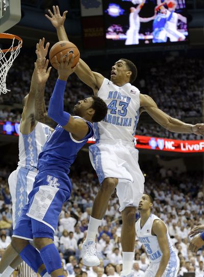 North Carolina's James Michael McAdoo, right, and Brice Johnson, left, defend as Kentucky's James Young drives to the basket. (Associated Press)