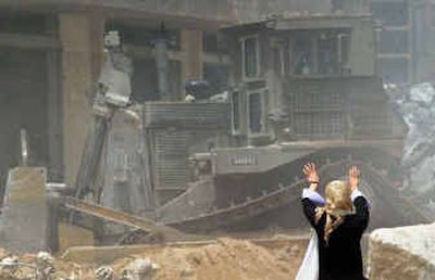 
A Palestinian woman gestures as an Israeli armored bulldozer demolishes a house in the Rafah refugee camp southern Gaza Strip, Friday.   
 (Associated Press / The Spokesman-Review)
