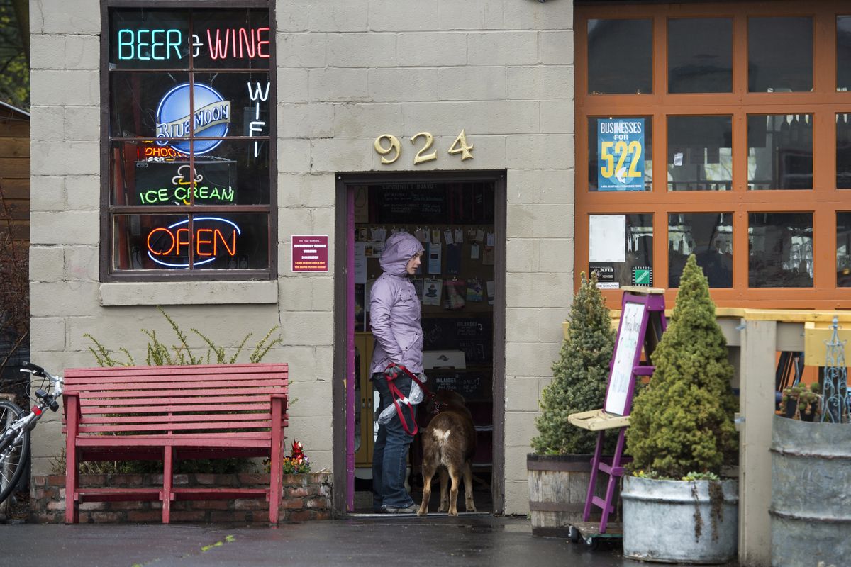 Katie Bell and her dog Rugby visit The Shop in the South Perry District in Spokane on Thursday. They live in the neighborhood. (Dan Pelle)