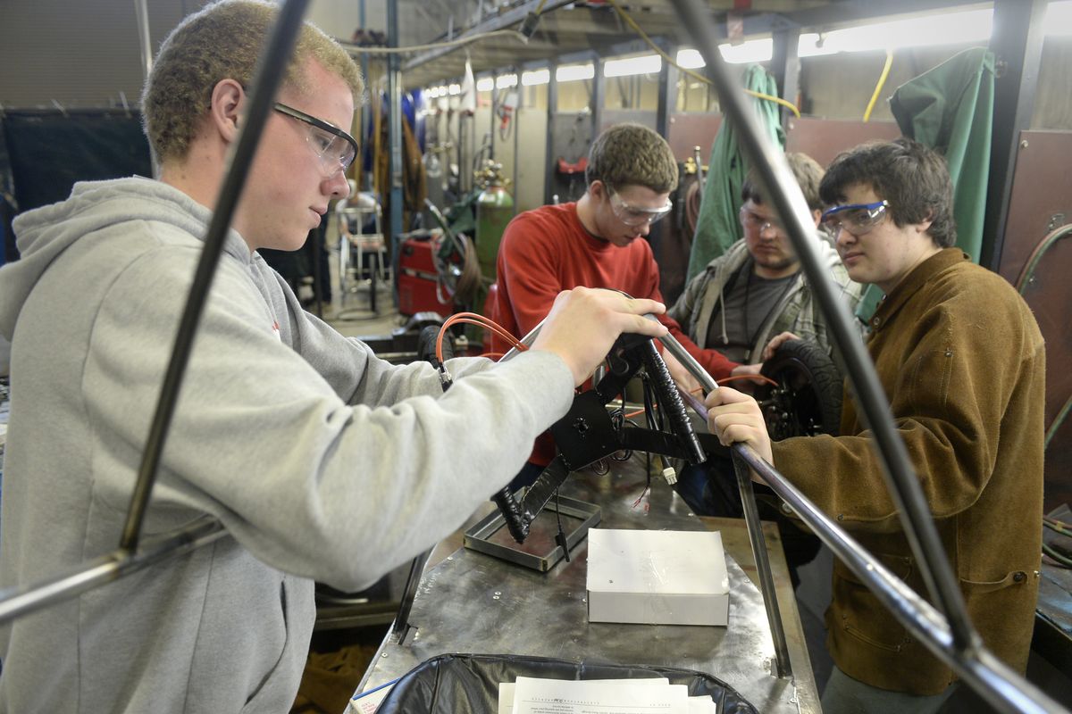 Kevin Huggins, left, installs controls and battery monitoring equipment with his teammates Joshua Rux, Nate Watson and A.J. Wood in the shop on Monday at Riverside High School. The students in the Riverside Technical Academy program are building a high tech house, while these students are building a fleet of electric vehicles to compete in Electrathon events. (Jesse Tinsley)