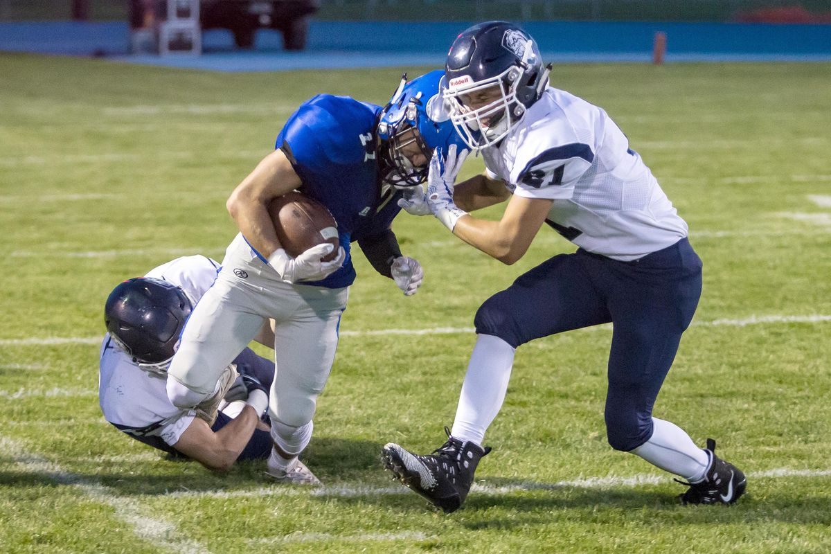 Coeur d’Alene’s Ethan Garitone gets taken down by Gonzaga Prep’s Daniel Siwinski, left, and Jacob Parola during the second quarter. (For The Spokesman-Review / Bruce Twitchell)