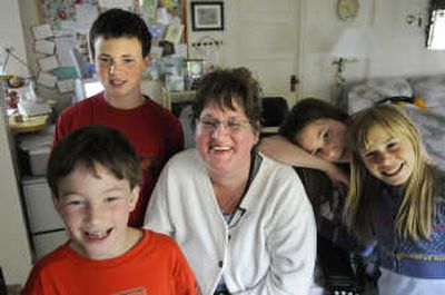
Jenny Hoff is surrounded by neighborhood children who  do chores around Hoff's Spokane Valley home. The children, from left Ezra Way, Nate White, Lizzy Way and Davien Engeberg, work on an eye sensor computer that doesn't require hands or voice to operate. 
 (DAN PELLE Photos / The Spokesman-Review)