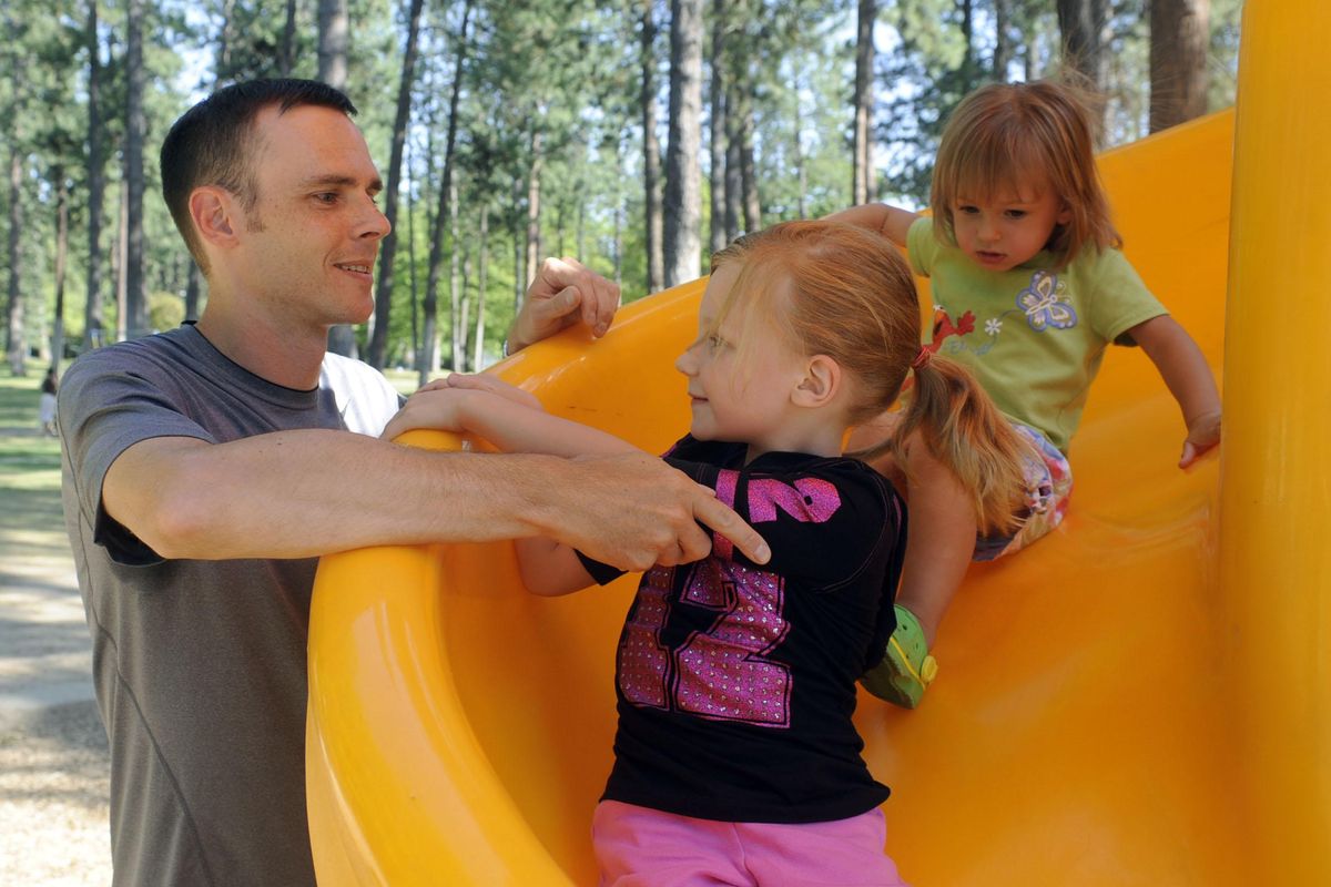 FILE – Mike Wiser was appointed to a vacant Spokane Public Schools board of directors seat, Tuesday, March 14, 2017. Wiser is the vice president of Strategic Planning for CHAS Health. In this 2009 photo Wiser helps his daughters Olivia, 5, and Allie, 2, down the slide at Comstock Park. That year, Wiser, who had been a business consultant, curtailed his business to take care of the children. (Jesse Tinsley / The Spokesman-Review)