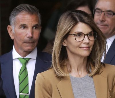 In this April 3, 2019 photo, actress Lori Loughlin, front, and husband, clothing designer Mossimo Giannulli, left, depart federal court in Boston after facing charges in a nationwide college admissions bribery scandal. (Steven Senne / associated press)