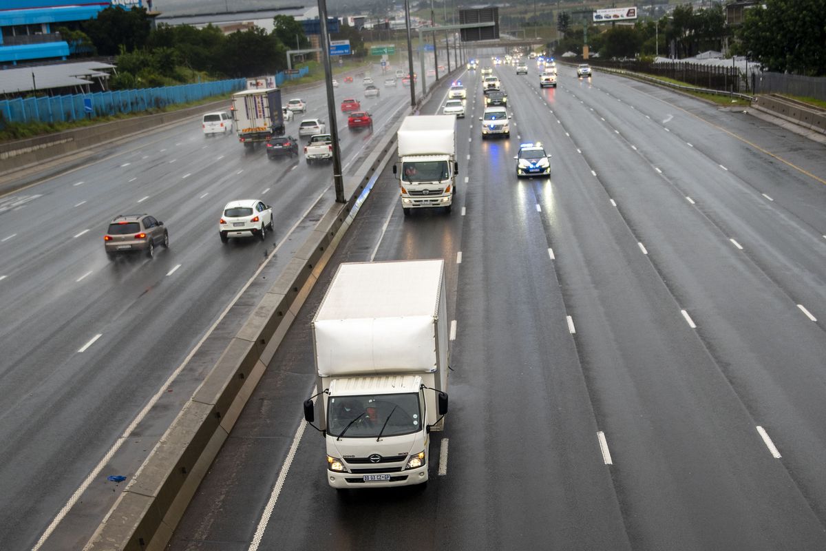 South African law enforcement vehicles provide security for two refrigeration trucks transporting the AstraZenica vaccine that arrived earlier from India, near Johannesburg, Monday, Feb. 1, 2021. South Africa has welcomed the delivery of its first 1 million doses and will be administered to frontline workers in approximately two weeks.  (Alet Pretorius)