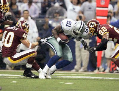
Terrell Owens (81), tackled by Washington's Adam Archuleta (40) and Carlos Rogers, had surgery on a broken finger. 
 (Associated Press / The Spokesman-Review)