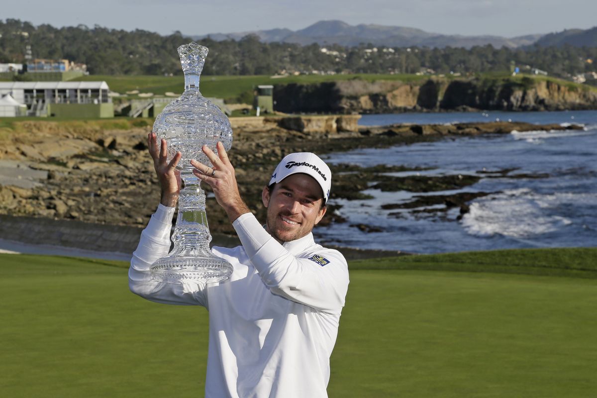 Nick Taylor holds up the trophy after winning the AT&T Pebble Beach National Pro-Am on Feb. 9, qualifying him for the Masters.  (Eric Risberg)