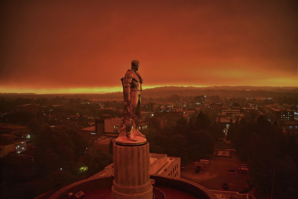 This drone photo provided by Michael Mann shows the Oregon Capitol building, with its "Oregon Pioneer" bronze sculpture atop the dome, with skies filled with smoke and ash from wildfires as a backdrop in Salem, Ore., on Sept. 8, 2020. Fires continued to rage across the West Coast on Monday, Sept. 21, 2020.  (Michael Mann)