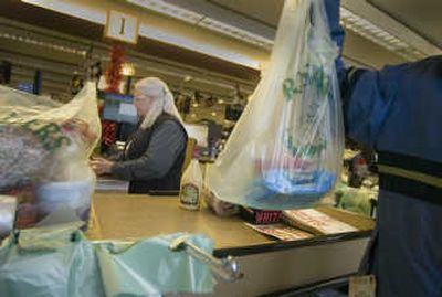 
Shoppers at the Rosauers in Browne's Addition can now have their purchases bagged in paper or the new green-tinted Eco Hippo plastic bags. Sarah Tupper loads up a bag while checker Ardi Stanhop finishes the transaction. 
 (Christopher Anderson / The Spokesman-Review)