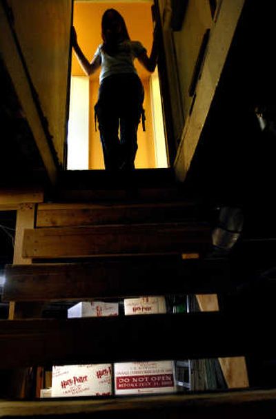 
Mallory Schuyler stands in the basement entry of the Tinman Gallery on Thursday where boxes of the latest Harry Potter books are hidden until the official release at 12:01 a.m. Saturday. 
 (Brian Plonka / The Spokesman-Review)