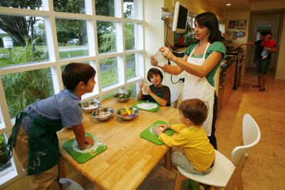 Mimi Chacin makes pizzas with sons Ian, 4, left, and Diego, 9,  and nephew Andrew Winzey, 2,  at her Miami Shores, Fla., home. Chacin’s husband recently lost his job, but the children’s cooking classes she teaches have remained full. (Associated Press / The Spokesman-Review)
