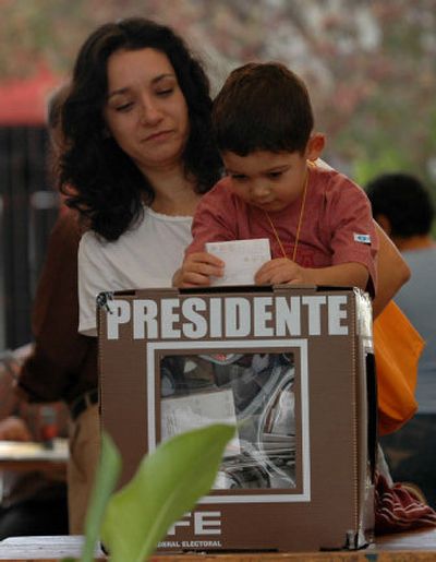 A mother holds her son as he casts her vote Sunday during presidential elecions in Oaxaca, in southern Mexico.
(Associated Press / The Spokesman-Review)