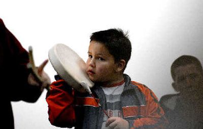 
Six-year-old Cody Doney plays music while his grandmother, Norma Peone,  teaches students at North Idaho College how to play the stick game. 
 (The Spokesman-Review)