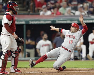 Cincinnati Reds' Joey Votto, right, scores as Cleveland Indians catcher Roberto Perez watches during the ninth inning of a baseball game Tuesday, July 10, 2018, in Cleveland. The Reds won 7-4. (Tony Dejak / AP)