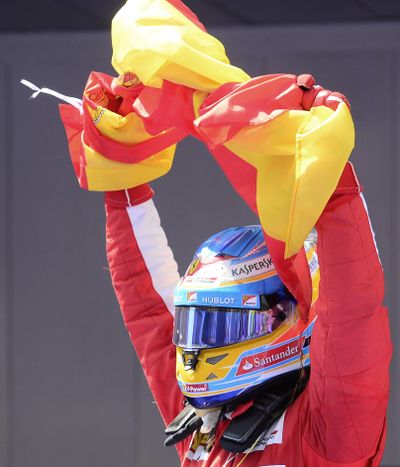 Ferrari driver Fernando Alonso of Spain celebrates his victory in front of home fans after winning the F-1 Spanish Grand Prix. (Associated Press)