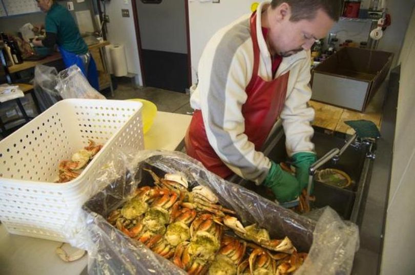 Shawn Offield carefully cleans steamed Dungeness crabs to fill special orders in the back room at Williams Seafood, which is owned by the Offield family, Tuesday, Dec. 22, 2015. The price for crab products is up this year with a shortage of some types of crabs. Owner Mike Offield said they’ve kept their margins the same, but raised their prices according to their costs. (Jesse Tinsley / The Spokesman-Review)