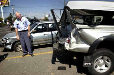 Letter carrier Jerry Reidt hangs his head after looking at his wrecked 2001 Toyota Tacoma pickup in the parking lot of the Opportunity post office on Sprague Avenue on Tuesday. Reidt's truck was one of the parked vehicles damaged when the driver of a truck apparently blacked out.
(Holly Pickett / The Spokesman-Review)