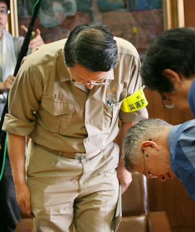 
Tsunehisa Katsumata, bottom right, bows to Kashiwazaki Mayor Hiroshi Aida, left, in apology for problems at a nuclear power plant following an earthquake. Associated Press
 (Associated Press / The Spokesman-Review)