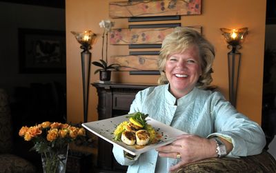 Tana Rekofke, proprietor of Vintages 611, holds a scallops entree.  (CHRISTOPHER ANDERSON / The Spokesman-Review)
