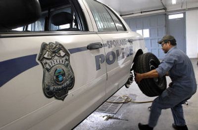 
Bill Hansen, city mechanic, installs a tire after a rear brake job on a police vehicle with 94,000 miles at the fleet services center on  Normandie Street recently. 
 (Dan Pelle / The Spokesman-Review)